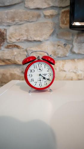 a red alarm clock sitting on top of a table at Apartman Genio in Žminj