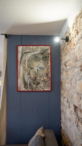 a painting hanging on a blue wall in a room at Apartman Genio in Žminj