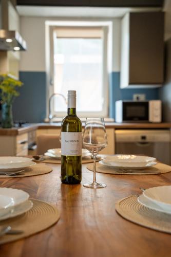 a bottle of wine and a wine glass on a table at Apartman Genio in Žminj
