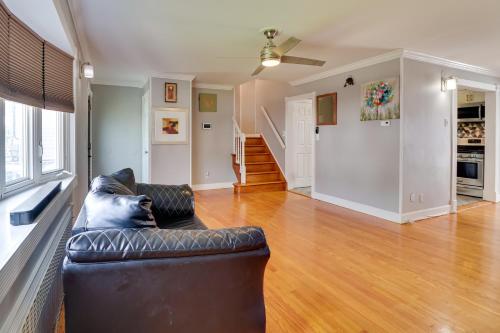 a living room with a black leather couch and wooden floors at 5 Mi to Dtwn Newark Hillside Vacation Rental in Hillside