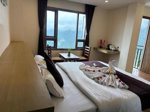 a bedroom with a large bed with a large window at Hotel Swastik Inn in Gangtok