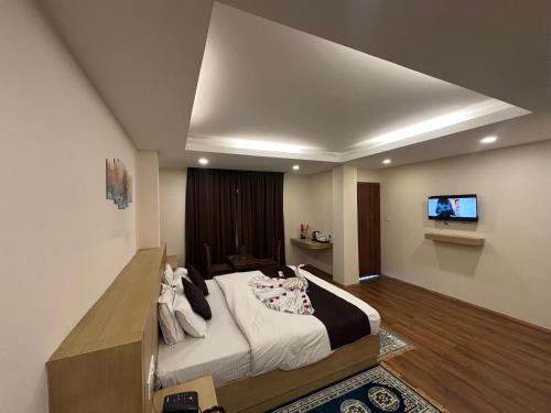 a bedroom with a large bed and a flat screen tv at Hotel Swastik Inn in Gangtok