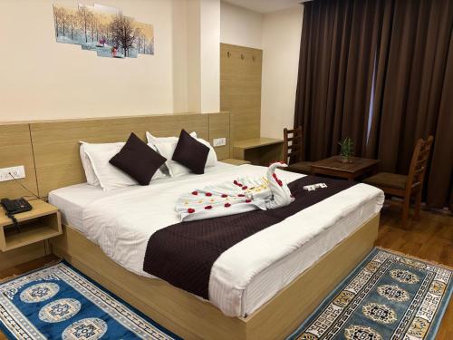 a bedroom with a large bed with decorations on it at Hotel Swastik Inn in Gangtok