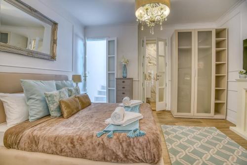 a bedroom with a large bed with two hats on it at Modern Oasis Near Mdina with Rooftop Pool & View in Rabat