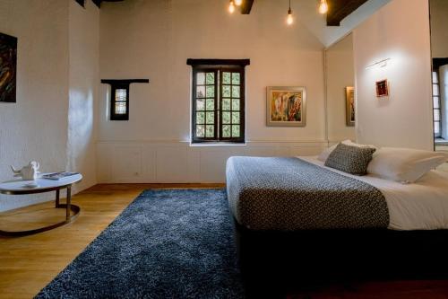 a bedroom with a bed and a table and a window at La Maison du Prévôt in Albi