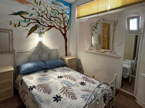 a bedroom with a bed with a tree painted on the wall at Casa Lasca in San Marzano di San Giuseppe