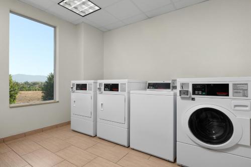 a laundry room with three washing machines and a window at Fairfield Inn & Suites Riverside Corona/Norco in Norco