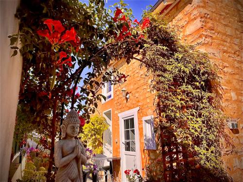 a statue in front of a building with flowers at Maison cocooning in Châteauroux