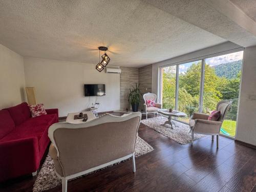 a living room with a red couch and chairs at Rest House in Olovo