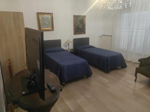 Antonelli apartments في نوفارا: غرفة نوم بها سريرين وتلفزيون بشاشة مسطحة