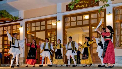 a group of people dancing in front of a store at Hotel Apartments Sikia in Kato Gatzea