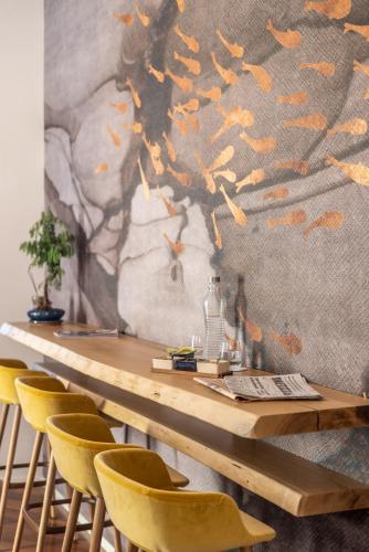 a dining room with a table and yellow chairs at Noto Boutique Hotel in Noto