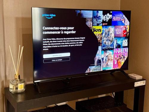 a flat screen tv sitting on top of a table at Charmant studio au calme, Stationnement gratuit in Saint-Denis
