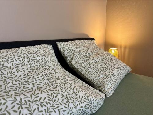 a bed with two pillows on top of it at Charmant studio au calme, Stationnement gratuit in Saint-Denis