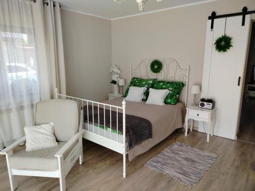 a bedroom with a bed with green pillows and a chair at Sielskie Mazury in Świętajno