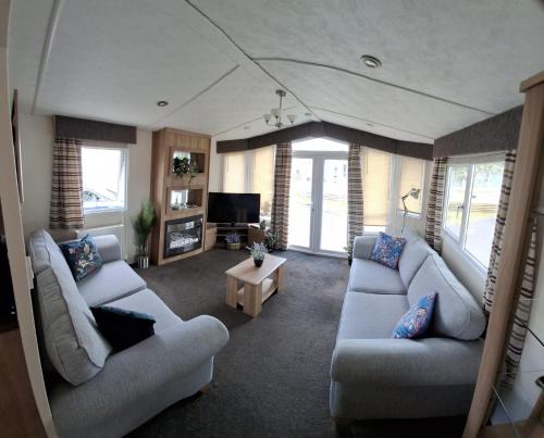 a living room with two couches and a tv at Blue Water Retreat Dawlish Warren Nr Beach in Dawlish Warren