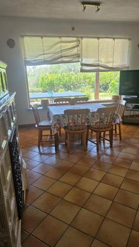 a dining room with a table and chairs and a window at PM 25 Via Trepene in Castellonorato