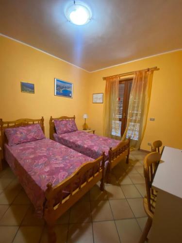 a bedroom with two beds and a window at PM 25 Via Trepene in Castellonorato