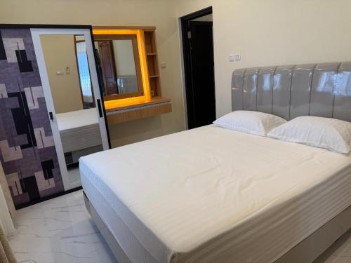 a large bed in a bedroom with a mirror at Eton Asia Villas-Kota Bunga in Puncak