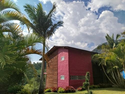 a red building with a palm tree in front of it at Jardín Utopía in Jardin