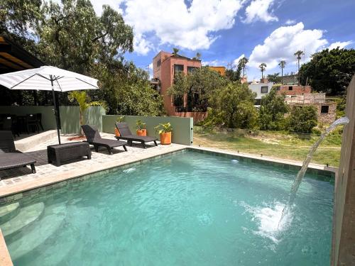 a swimming pool with a water fountain at Casona San Cayetano Suites & Lofts & Spa by SCE in Guanajuato
