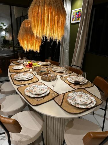 a table with plates and wine glasses on it at Chalevillebarrinha Presidencial Terrace Suite in Barrinha