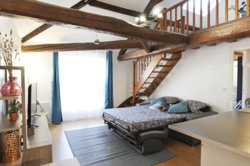 a living room with a bed and a staircase at Résidence proche Vallée de Chevreuse in Le Mesnil-Saint-Denis