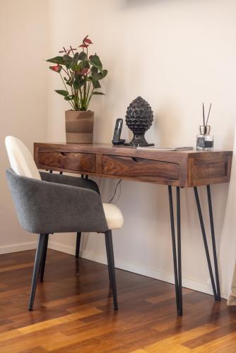 a wooden desk with a chair and a plant at Noto Boutique Hotel in Noto