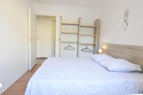 a bedroom with a white bed with a wooden headboard at Résidence proche Vallée de Chevreuse in Le Mesnil-Saint-Denis