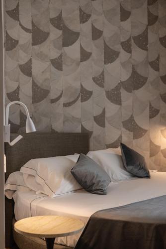 a bed with two pillows and a table in a room at Noto Boutique Hotel in Noto