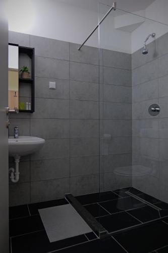a bathroom with a glass shower and a sink at Hotel Venatus in Zalaegerszeg