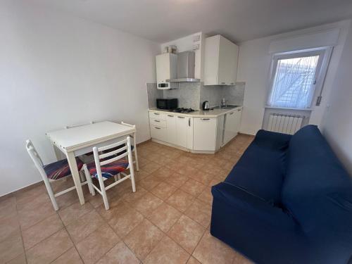 a living room with a table and a blue couch at Calle Coppo appartamento nel centro storico - Agenzia Cocal in Caorle