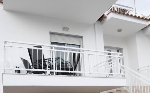a white house with a white balcony at KERÉ Living in Keramotí
