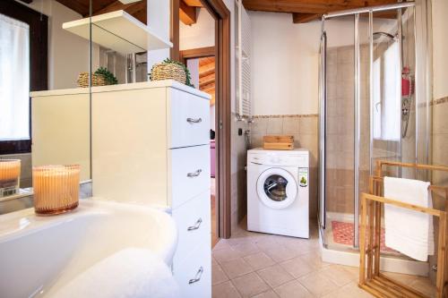 y baño con bañera y lavadora. en Din Don House, en Cernobbio