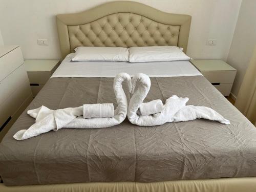 Dos toallas en una cama con dos zapatillas en Ilary Home, en Venecia