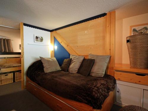 une chambre avec un lit avec une tête de lit en bois dans l'établissement Duplex Calme et Confortable aux Arcs 1800 avec Balcon, Proche Navettes et Parkings - FR-1-346-337, à Arc 1800