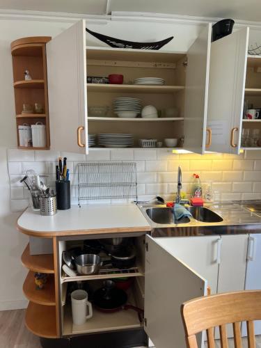 a kitchen with white cabinets and a sink at Gäst lägenheten med egen terrass in Falkenberg