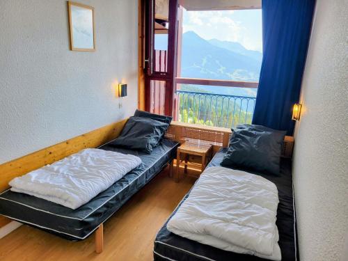 a room with two beds and a large window at Appartement 6 pers · Balcon · Wifi gratuit · Parking - FR-1-346-559 in Arc 1800