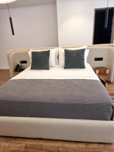 a large bed with black and white sheets and pillows at Palorto Inn in Gjirokastër