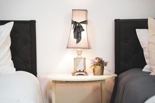 a table with a lamp on it next to two beds at Zephyrhills House for 4 people WiFi BBQ Mini Golf in Zephyrhills