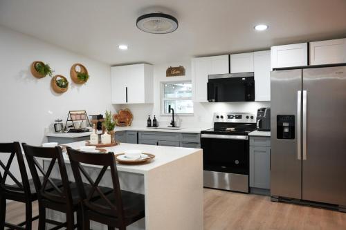 a kitchen with a refrigerator and a table with chairs at Zephyrhills House for 4 people WiFi BBQ Mini Golf in Zephyrhills