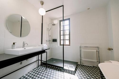 a white bathroom with a sink and a mirror at La Maison du Prévôt in Albi