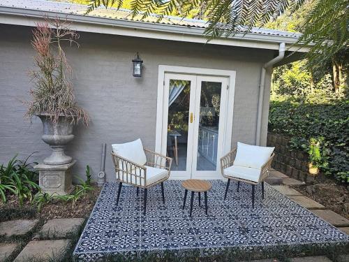 a patio with two chairs and a table and a door at The Rose Cottage in Hilton