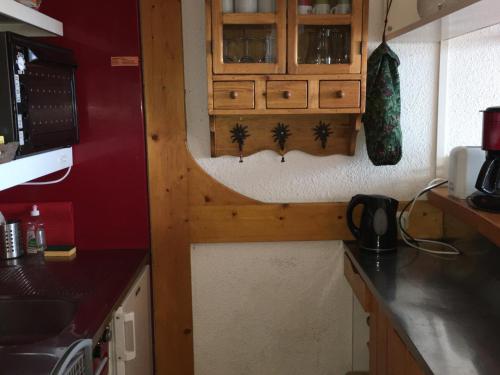 une cuisine avec des armoires en bois et un comptoir dans l'établissement Appartement lumineux Centre Station avec Balcon et Parking - FR-1-346-523, à Arc 1800