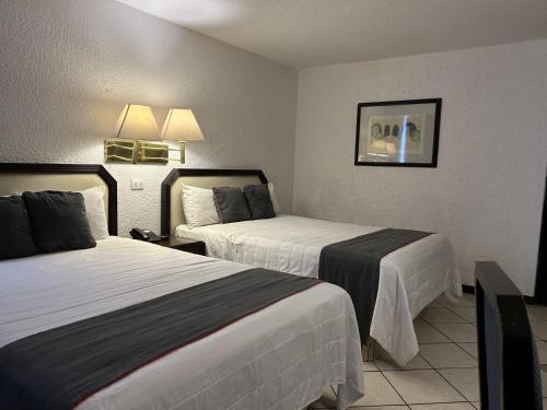 a hotel room with two beds in it at Hotel Del Portal, Puebla in Puebla