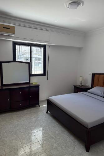 タンジェにあるBeachfront Apartment Tangerのベッドと薄型テレビのある寝室