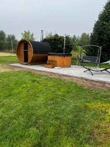a round wooden building with a table and a bench at Wichrowa chata in Joniec