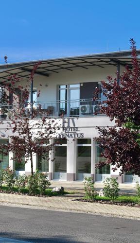 a white building with a sign on the side of it at Hotel Venatus in Zalaegerszeg