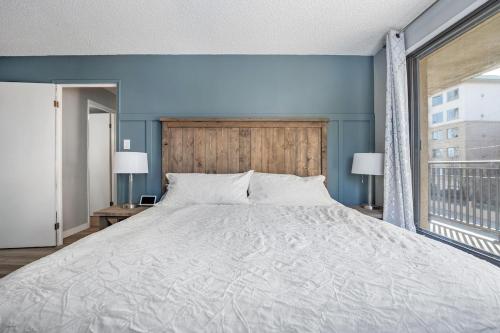 une chambre avec un grand lit et une grande fenêtre dans l'établissement YYC HiddenGem, à Calgary