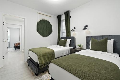 ジャージー・シティーにある3BR - Parking Privado y WiFi Rápido Cerca MetLifeのベッドルーム(緑と白のベッド2台付)
